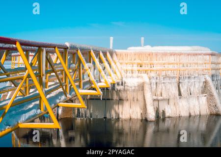 Eisbedeckte Metallkonstruktion eines kleinen Staudamms Stockfoto