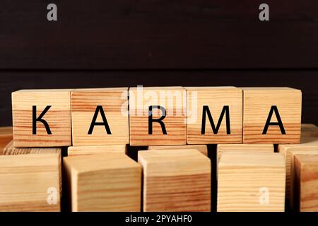 Wort Karma aus Würfeln mit Buchstaben auf dunklem Hintergrund Stockfoto