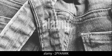 Modische Denimkleidung. Details und Nähte auf rauem Denim. Schwarzweißfotografie Stockfoto