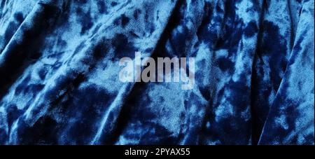 Samtiger Velours-Hintergrund mit leuchtenden Licht- und dunklen Schatten. Hintergrund für Theater- und Modedesigns. Schöner blauer Stoff mit Überlauf. Weichzeichner Stockfoto