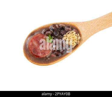 Typische brasilianische Feijoada in einem Holzlöffel isoliert auf weißem Hintergrund. Stockfoto