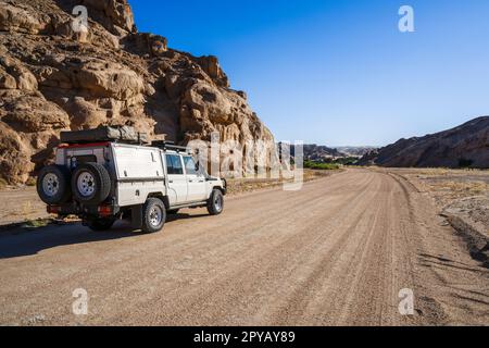 Weißes Selbstfahrer-Fahrzeug steht auf einer Schotterstraße in der namibischen Wüste. Mondlandschaft, Swakopmund, Namibia, Afrika Stockfoto