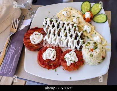 Gebratenes Souvlaki und gegrillte Tomaten. Stockfoto