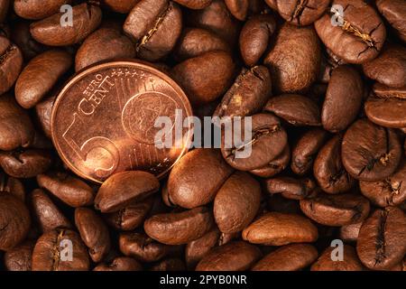 Geröstete Kaffeebohnen und eine Nahaufnahme von fünf Euro-Cent-Münzen Stockfoto