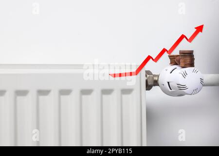 Steigende Energiekosten. Aufsteigender roter Pfeil und Münzen auf einem Heizkörper. Die Lebenshaltungskostenkrise. Rezessionsinflationskonzept Kopierraum Stockfoto