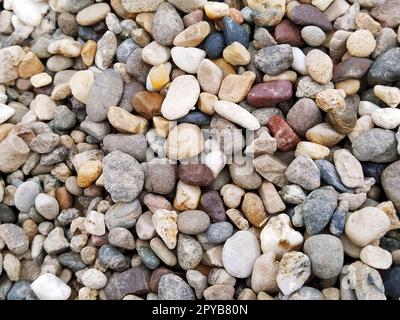 Kiesel als Hintergrundbild. Weiße, graue, braune, rötliche kleine Steine oder Kiesel. Stockfoto