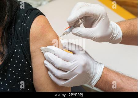 Die Injektion für die Grippeimpfung erfolgt im Oberarm Stockfoto