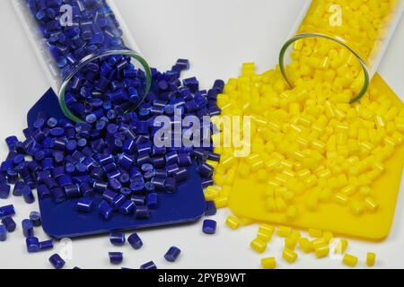 Blaue und gelbe Kunststoffharze in Reagenzgläsern im Labor mit farbigen Probenplatten Stockfoto