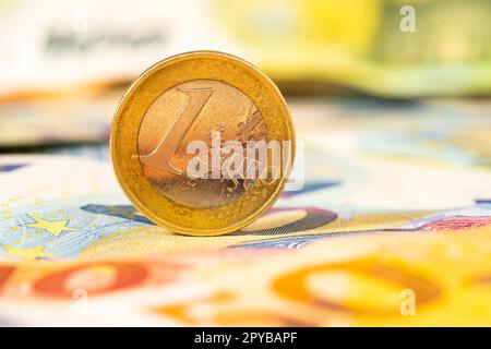 Eine Euro-Münze auf den Banknoten Stockfoto