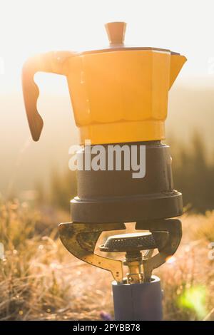 Nahaufnahme des Campingkessels am Gasbrenner im Sonnenschein Konzeptfoto Stockfoto