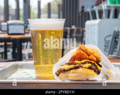 Mexiko, APR 27 2023 - Nahaufnahme von Bier und Burger aus Shake Shack und Burger Stockfoto