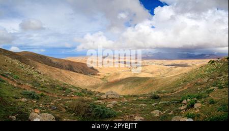 BETANCURIA, SPANIEN - FEBRUAR 16: (ANMERKUNG: Für dieses Bild wurde ein abgestufter Farbfilter verwendet. Das Bild ist ein digitales Panorama-Composite.) Ein Gewitter nähert sich dem Mirador de Guise y Ayose Aussichtspunkt am 16. Februar 2023 in Betancuria, Spanien. Stockfoto