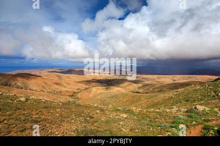 BETANCURIA, SPANIEN - FEBRUAR 16: (ANMERKUNG: Für dieses Bild wurde ein abgestufter Farbfilter verwendet. Das Bild ist ein digitales Composite mit hohem Dynamikbereich.) Ein Gewitter nähert sich dem Mirador de Guise y Ayose Aussichtspunkt am 16. Februar 2023 in Betancuria, Spanien. Stockfoto