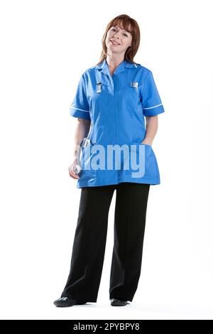 Gesundheitsfachkräfte: Entspannte Krankenschwester. Ein uniformierter Mediziner mit einem freundlichen Lächeln. Aus einer Serie von verwandten Bildern, in voller Länge isoliert auf weiß. Stockfoto