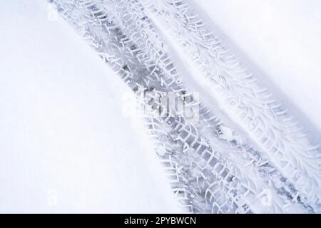 Spuren von Autoreifen im frischen Schnee Stockfoto