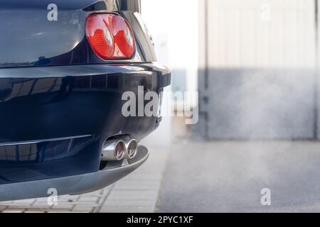 Rauch aus dem Auspuff eines Autos mit Benzinmotor Stockfoto