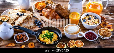 Das Frühstück wurde mit Kaffee, Eiern, Müsli und Croissants serviert Stockfoto