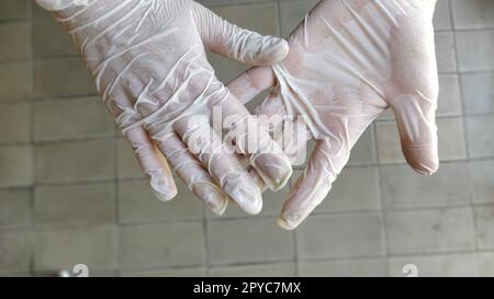 Hände in Operationshandschuhen. Gesten, die Hände reiben. Medizinische Handschuhe In Der Hand. Stockfoto