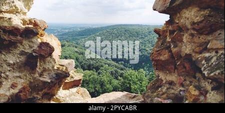 Ruinen einer alten Festung in Vrdnik, Sremska Mitrovica, Vojvodina, Serbien. Alte Steinmauern mit Bergketten im Hintergrund. Touristenattraktionen. Embrasur oder Fenster zur Beobachtung und Verteidigung Stockfoto