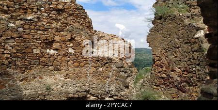 Ruinen einer alten Festung in Vrdnik, Sremska Mitrovica, Vojvodina, Serbien. Alte Steinmauern mit Bergketten im Hintergrund. Historische Sehenswürdigkeiten Stockfoto