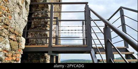 Ruinen einer alten Festung in Vrdnik, Sremska Mitrovica, Vojvodina, Serbien. Alte Steinmauern, Bergentfernungen. Metalltreppe zum Himmel. Historische Sehenswürdigkeiten. Stockfoto