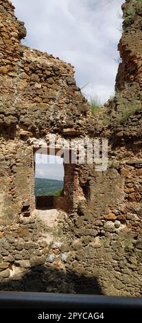 Ruinen einer alten Festung in Vrdnik, Sremska Mitrovica, Vojvodina, Serbien. Alte Steinmauern mit Bergketten im Hintergrund. Touristenattraktionen. Embrasur oder Fenster zur Beobachtung und Verteidigung Stockfoto