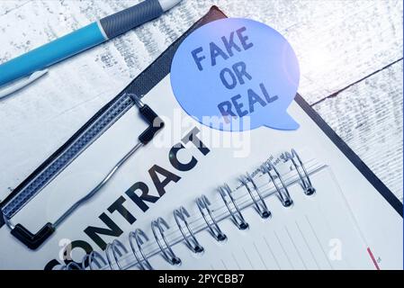 Handgeschriebenes Schild "Fake" oder "Real". Geschäftsmeinung Unterschied zwischen Fakten und absichtlicher Desinformation Stockfoto