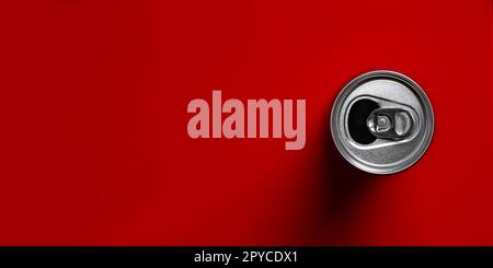 Offene Getränkedose direkt darüber auf rotem Hintergrund. Panoramabild mit Kopierbereich. Stockfoto