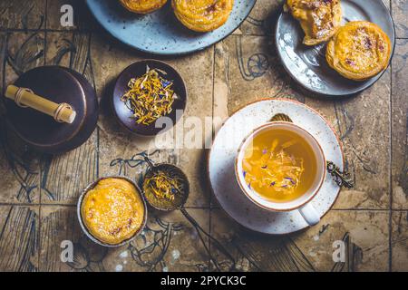 Pastel de nata mit einer Tasse Kräutertee, portugiesischem Süßei und Pudding-Gebäck Stockfoto