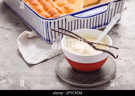 Buchteln, süße Brötchen aus Hefeteig mit Milch und Butter, serviert mit Vanillesauce Stockfoto