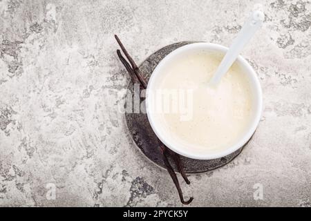 Hausgemachte Vanillesauce in einer kleinen Schüssel auf grauem Hintergrund Stockfoto