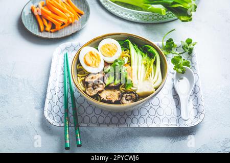 Ramen-Suppe mit Shiitake-Pilzen, Gemüse, Nudeln und Ei Stockfoto