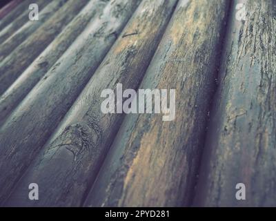 Ein Bauholz für den Einsatz im Bauwesen ohne Längssägen. Rundes Holzsortiment. Bruchstücke der Konstruktion von abgerundeten Holzstämmen. Der Einfluss von Feuchtigkeit auf Holz. Stockfoto