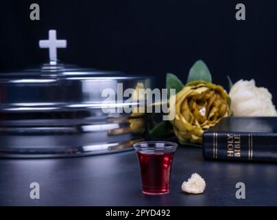 Die Kommunion, der Wein und die Brotsymbole auf schwarzem Hintergrund Stockfoto