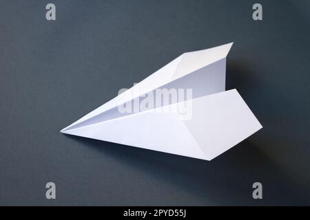Weißpapierflugzeug Origami isoliert auf grauem Hintergrund Stockfoto