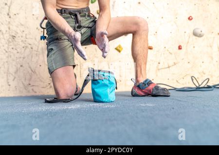 Auftragen von Magnesium auf die Hände aus dem Beutel vor dem Klettern auf die Kletterwand Stockfoto