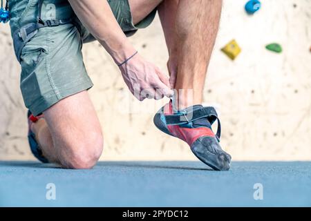 Kletterschuhe neben der Kletterwand anziehen Stockfoto