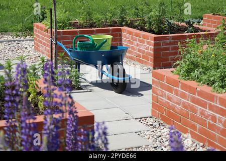 Frühlingshintergrund. Ein moderner Gemüsegarten mit erhöhten Backsteinbeeten. Hochbeete im Stadtgarten Stockfoto