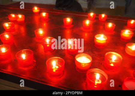 Memorial Day mit Kerze. Gedenkkerzen sind angezündet. Auf dem Friedhof brennen Kerzenflammen. Brennende Kerzen in der katholischen Kirche in Dubrovnik, Kroatien. Viele Kerzen. Die Flamme schwankt im Zug Stockfoto