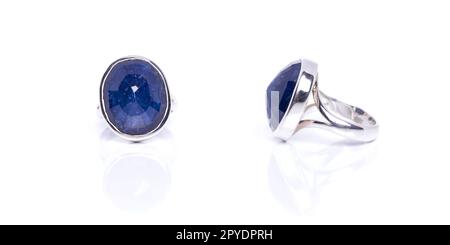 Blauer Sapphire-Ring auf weißem Hintergrund mit Reflexion. Sammlung von Accessoires für natürliche Edelsteine. Studioaufnahme Stockfoto