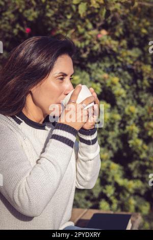 Eine Pause machen: Latina-Frau trinkt Kaffee im Garten Stockfoto