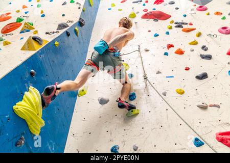 Auftragen von Magnesium auf die Hände aus dem Beutel vor dem Klettern auf die Kletterwand Stockfoto