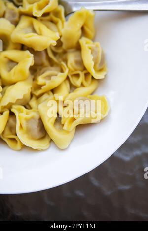 Hausgemachte italienische Ravioli gefüllt mit scharfem Fleisch, Nahaufnahme, auf einem Teller geschnitten. Stockfoto