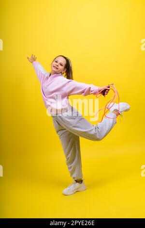 Bezauberndes weibliches Kind mit Seilspringen im Studio Stockfoto