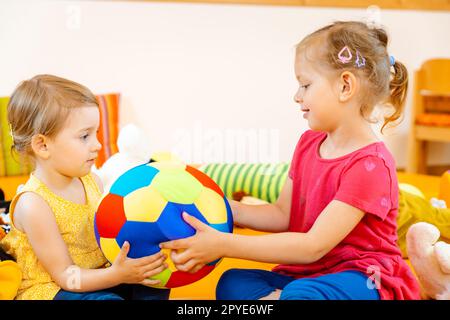 Zwei Mädchen in Schule Spiel Spaß mit einer Kugel Stockfoto