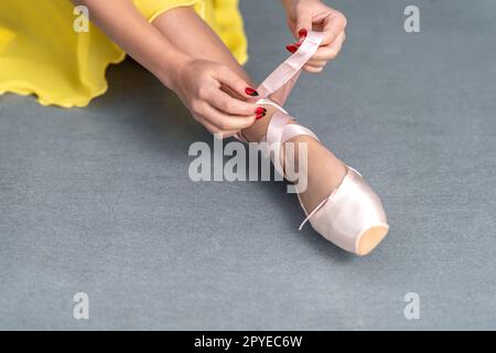 Schnürung von Ballettschuhen an den Füssen einer Ballerina Stockfoto