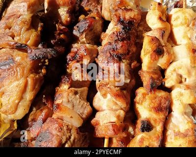 Gegrilltes Hähnchen, Schweinespieße auf Stöcken. Essen aus dem Restaurant. Schale in Einweg-Kunststoffverpackung. Rindfleischpasteten, chevapy. Lebensmittellieferung während der Selbstisolation Stockfoto