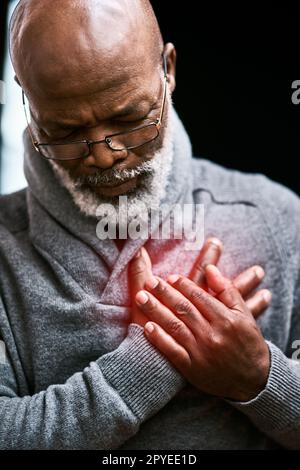 Ich leide an Brustschmerzen. Ein gutaussehender Senior-Mann, der seine Brust vor Schmerzen hält. Stockfoto