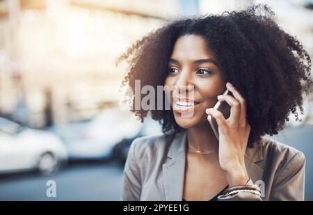 Sie ist diejenige, mit der alle reden wollen. Eine junge Geschäftsfrau, die in der Stadt telefoniert. Stockfoto