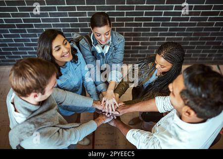 Machen wir es so. Hochwinkelaufnahme einer Gruppe junger Universitätsstudenten, die mit den Händen in einem Zusammentreffen stehen. Stockfoto